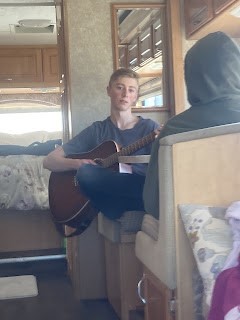 son playing his guitar